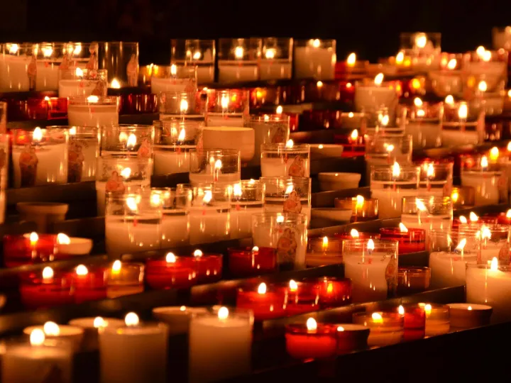 Rows of candles burning in a quiet chapel