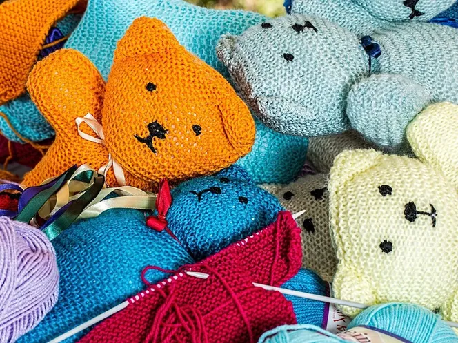 Hand-knitted woollen figures with knitting needles and balls of wool