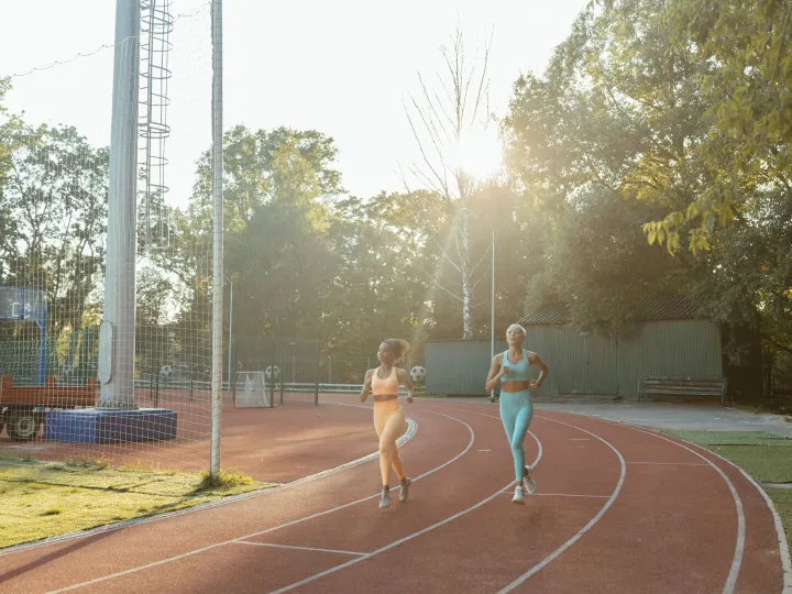 Two runners training on an outdoor track