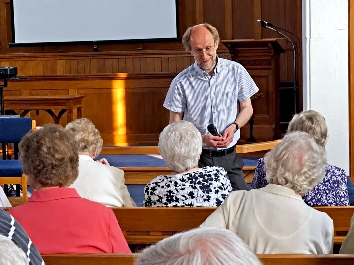 Andrew talking to a seated congregation in a Methodist chapel