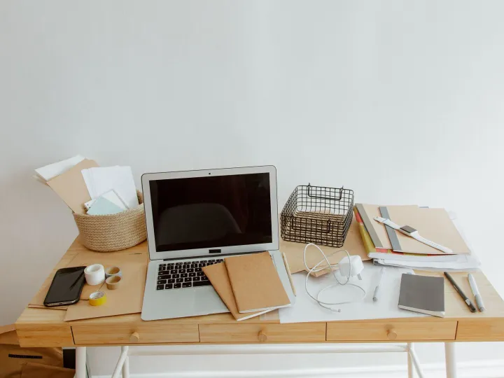 Tidy office desk with a laptop and notebooks