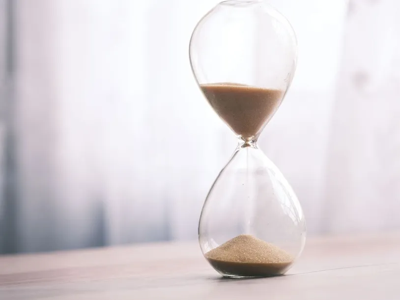 Minimalist hourglass filled with sand symbolizing