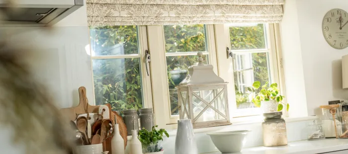 Patterned roman blinds in cream and white kitchen