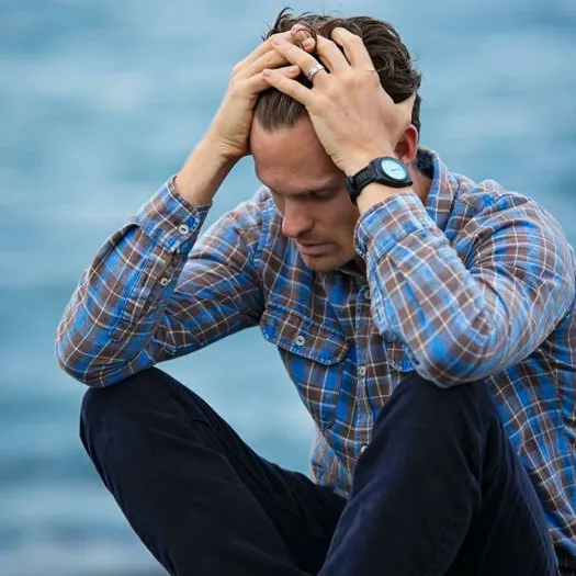 Man in Blue and Brown Plaid Dress Shirt Touching His Hair