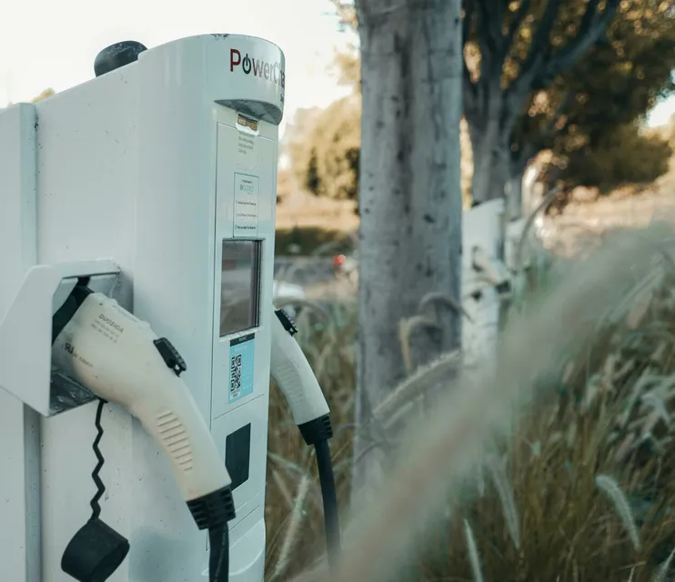 Electric vehicle charging station in an outdoor natural setting, highlighting sustainable technology.