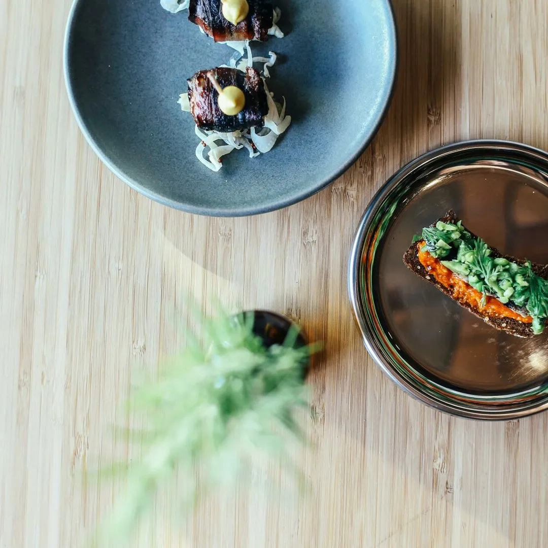 Elegant plating of gourmet dishes on wooden table, showcasing fine dining artistry.