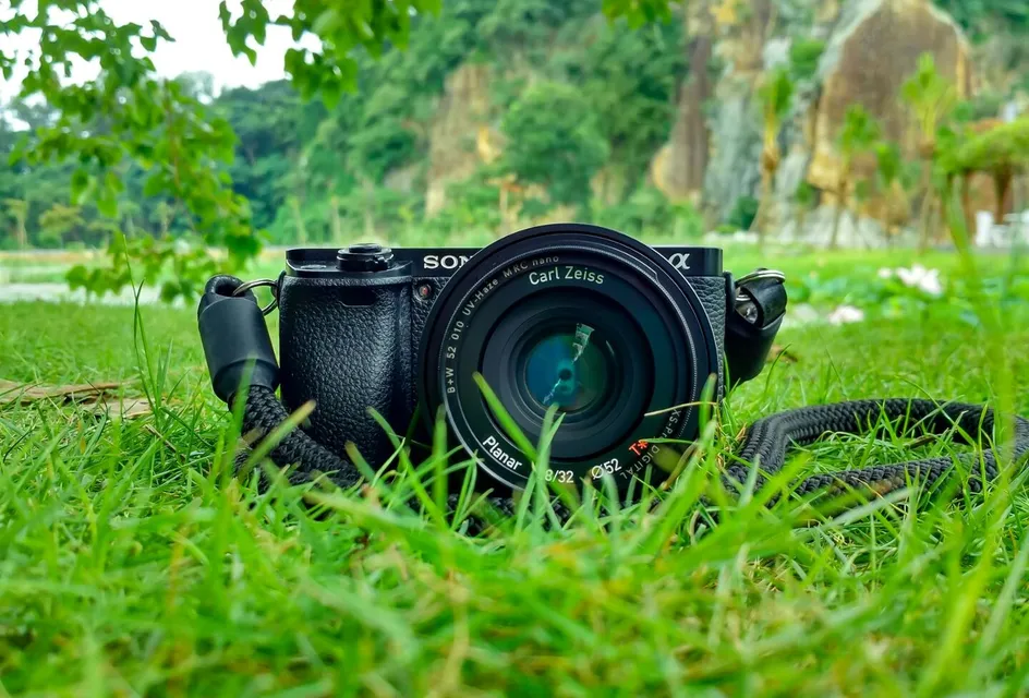 Camera with Carl Zeiss lens on grass, surrounded