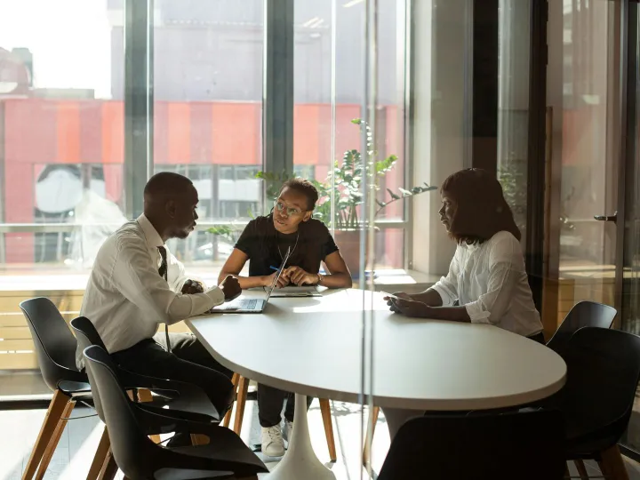 Three colleagues have a discussion around a table 