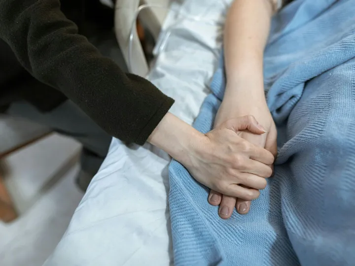 A comforting hand hold in a hospital, showcasing