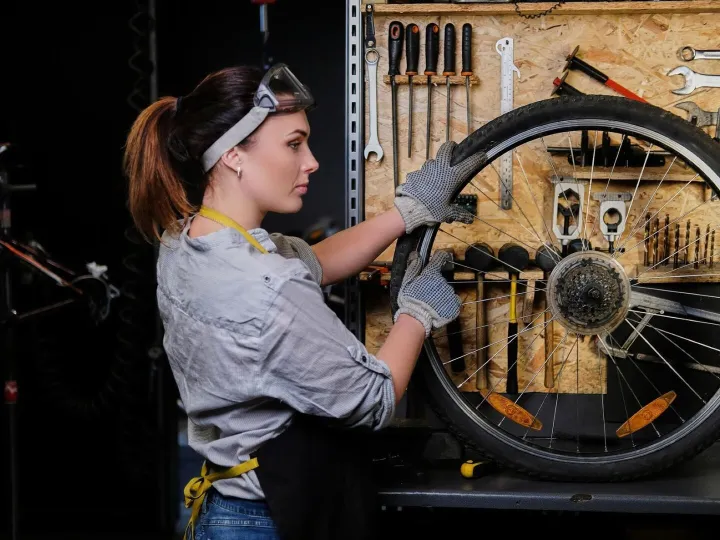 Beautiful female in working clothes, apron and goggles, repa