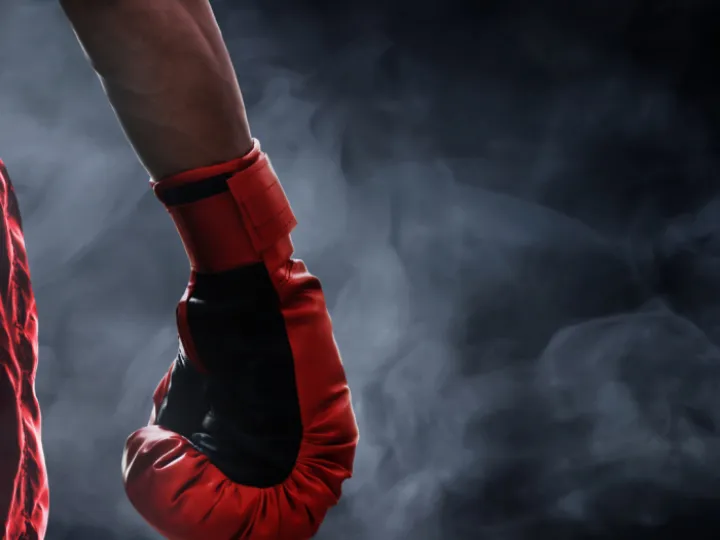 Red boxing glove in smoky light