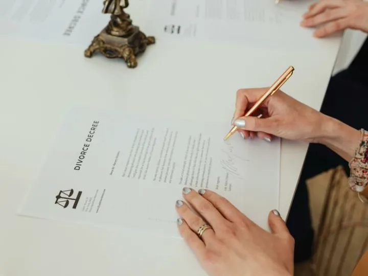 Person Signing on White Paper