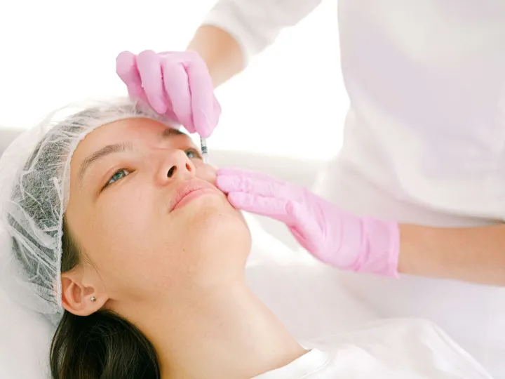Woman receives cosmetic injection in clinical setting, enhancing beauty using modern techniques.