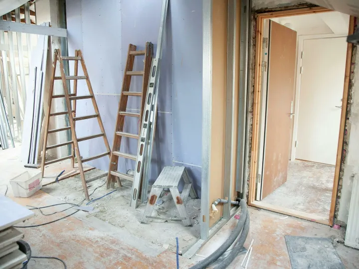 Construction site featuring ladders and tools in a home renovation setting.