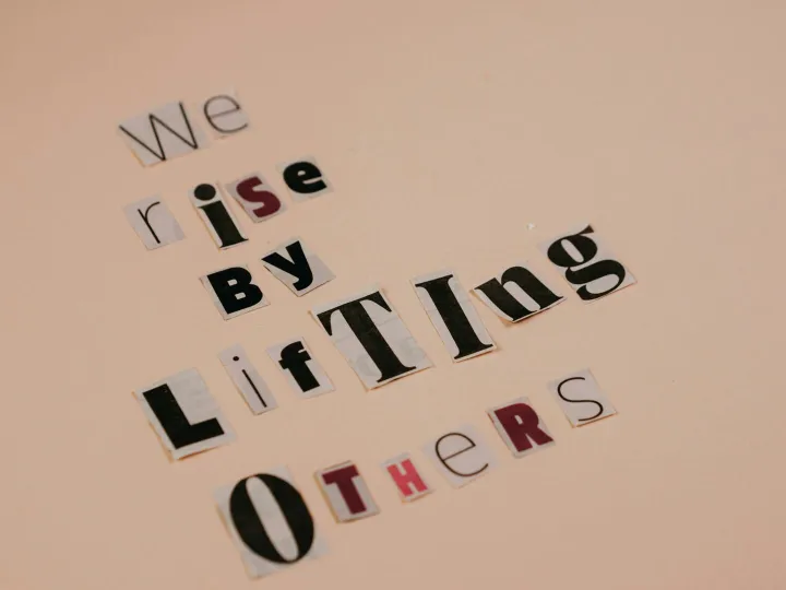 Cutout letters forming an inspirational quote on a beige background, encouraging positivity.