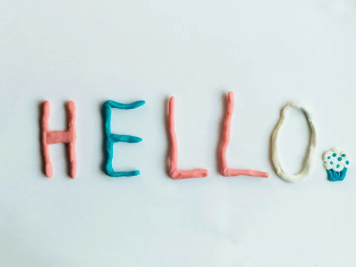 Creative hello greeting spelled out with colorful clay on a white background.