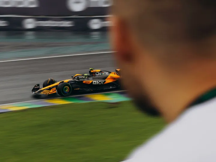 A high-speed Formula 1 car races around a track, captured in motion.