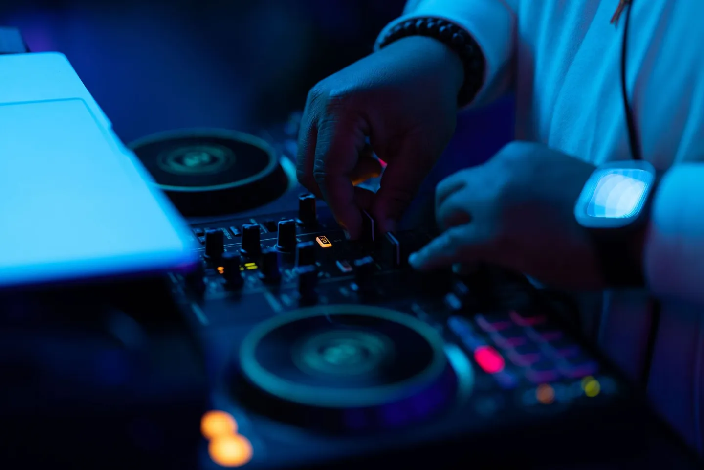 DJ adjusting sound mixer with hands, creating