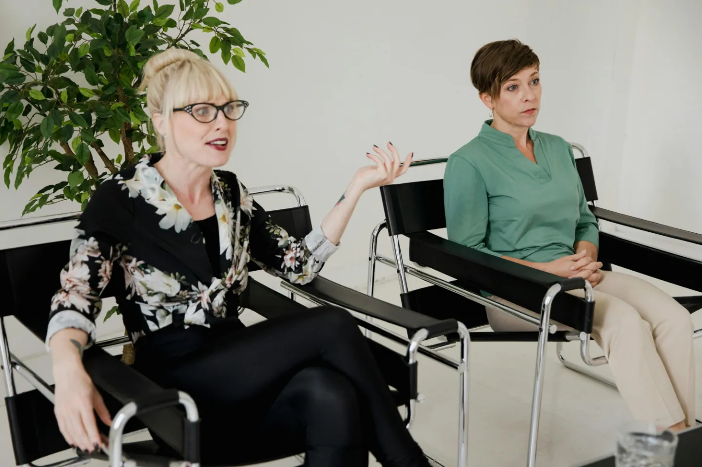 Women Sitting on Chairs in a Modern Interior and One Woman Talking