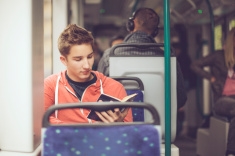 stock-photo-52709504-teenage-boy-reading-a-book-on-the-tram
