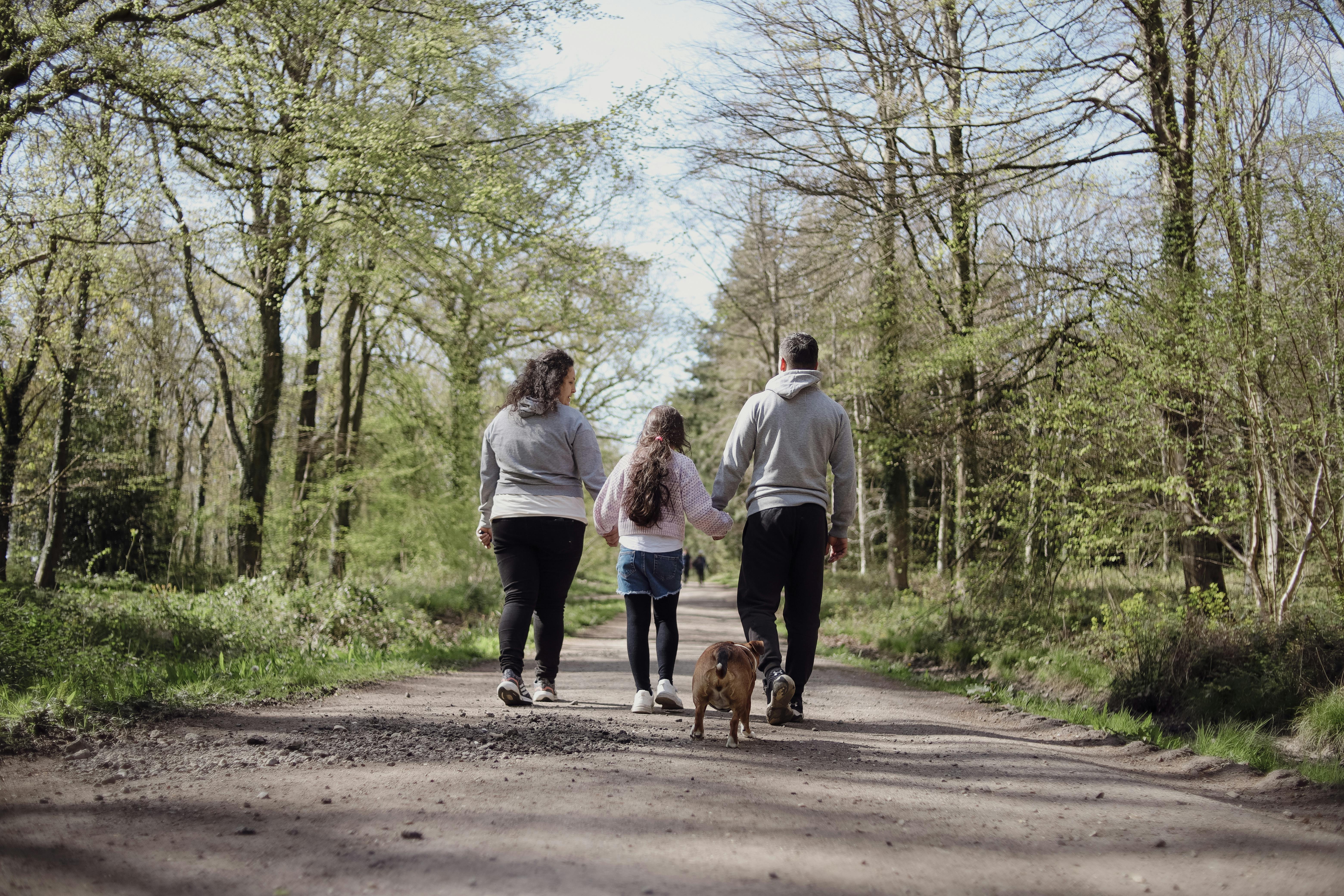 A family enjoying a walk with their dog on a