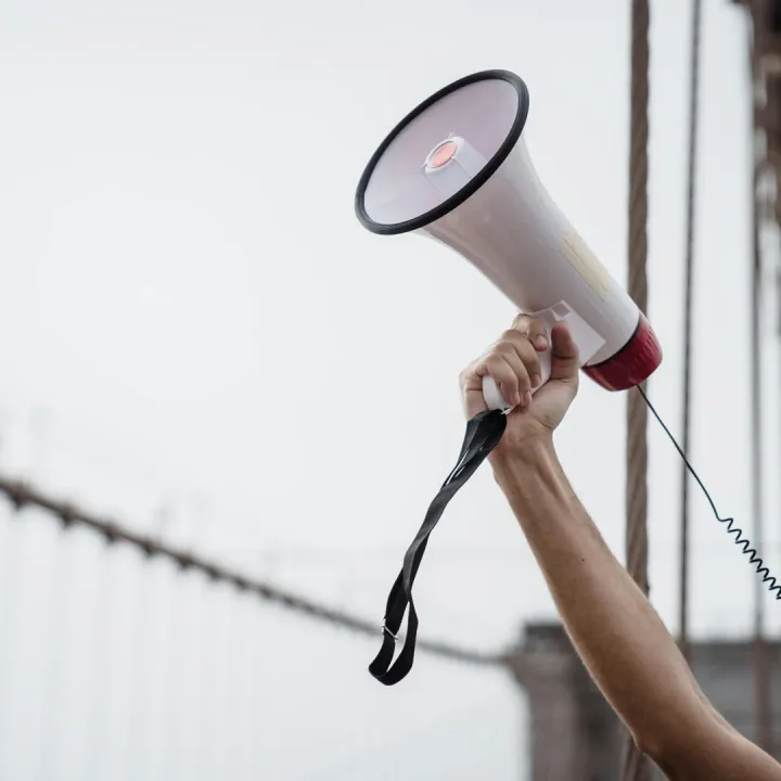 A hand holding a megaphone, symbolizing protest