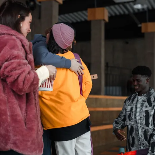 Friends greeting one another with a hug