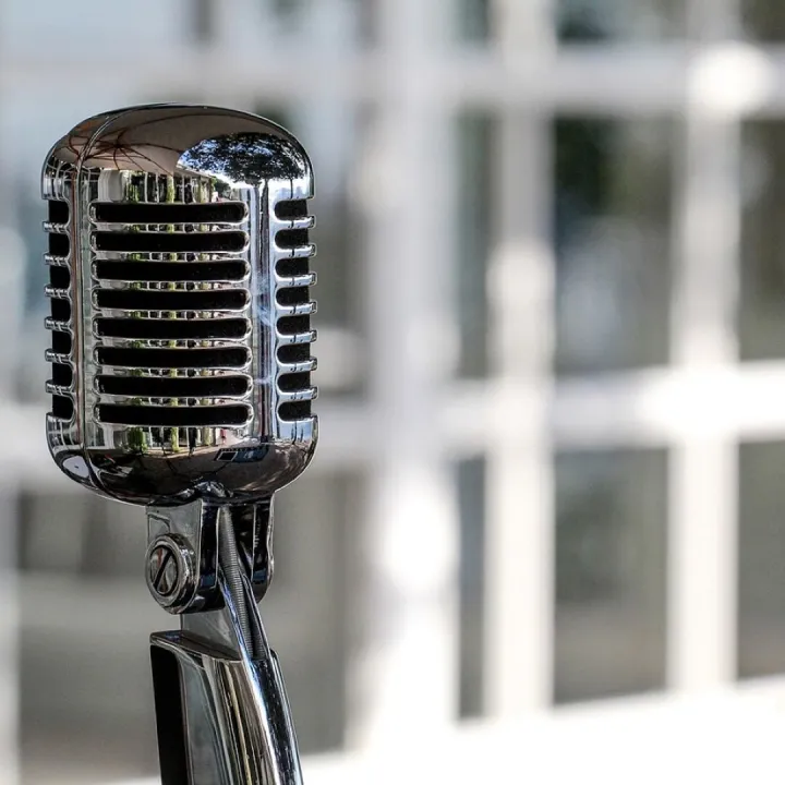 A vintage chrome microphone on a stand in a church hall