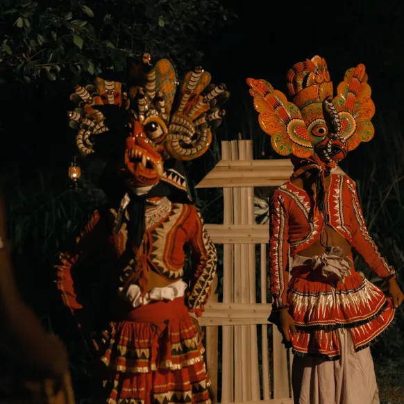 Masked traditional Sri Lankan dancers performing by night at Peacock Hill Sigiriya