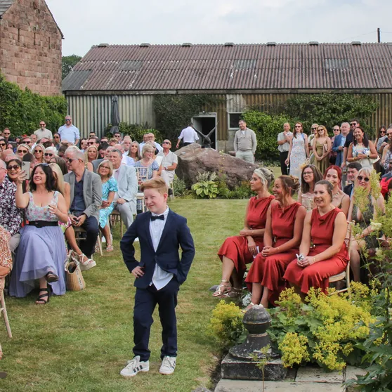 Guests seated on the lawn for an outdoor wedding ceremony at Mellor Knowl Farm