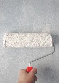 Decorator applying paint to a wall with a roller
