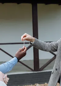 An estate agent handing a set of house keys to a client