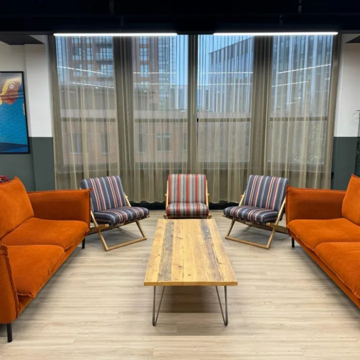 Breakout area with orange sofas and patterned chairs at Accenture Leeds