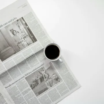 White Ceramic Mug On Top of a Newspaper