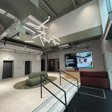 Modern office lobby with staircase and screen