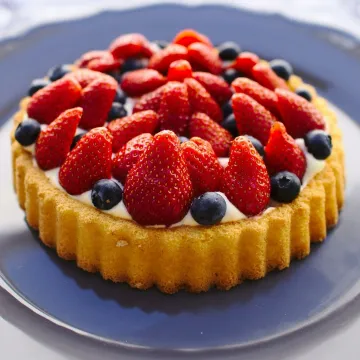 Scrumptious homemade fruit tart topped with fresh strawberries and blueberries.