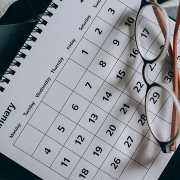 A close-up of a January calendar with eyeglasses
