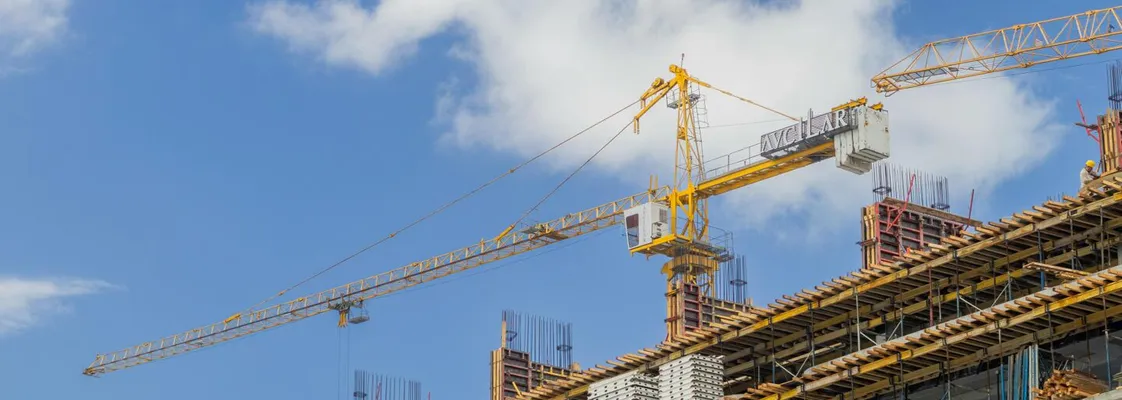A modern construction site with cranes against a