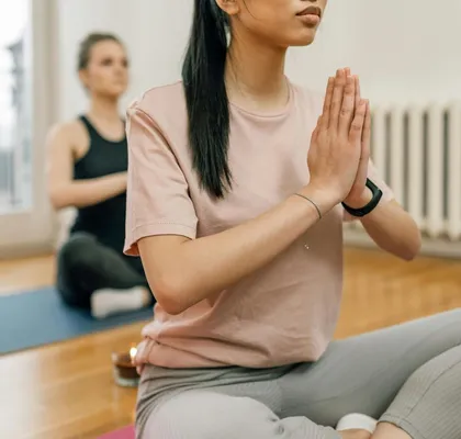 Two women meditate and practice yoga indoors