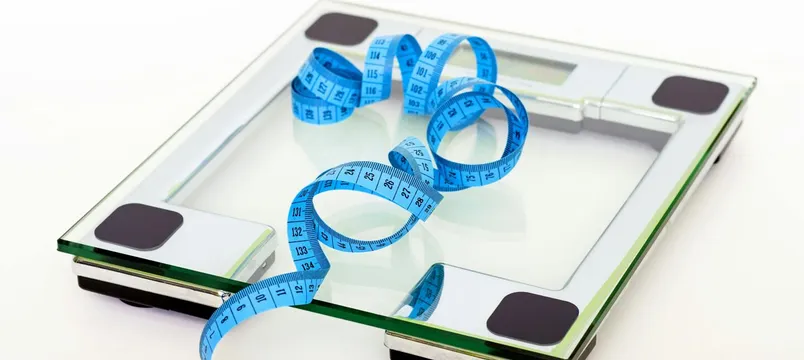 A digital glass weighing scale with a blue