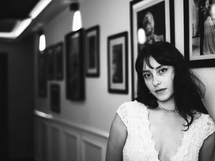 Elegant black and white portrait of a woman in a vintage-inspired hallway setting.