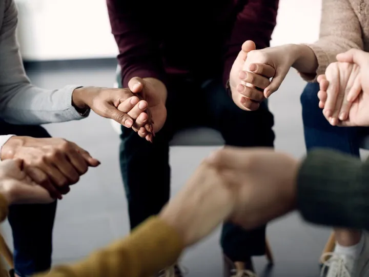 Closeup of group of people holding hands during psychotherap