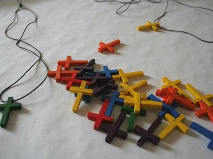 A pile of colourful wooden crosses on a table