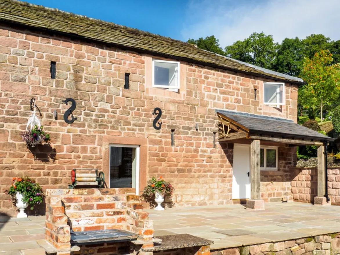 The patio and brick built barbecue outside Otters Retreat holiday cottage
