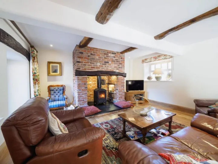 The lounge at Otters Retreat with an inglenook fireplace and log burning stove