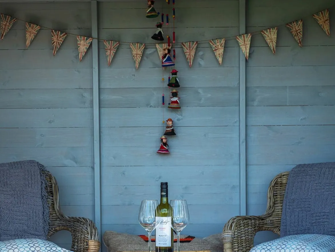 Inside the summerhouse with wine and wicker chairs