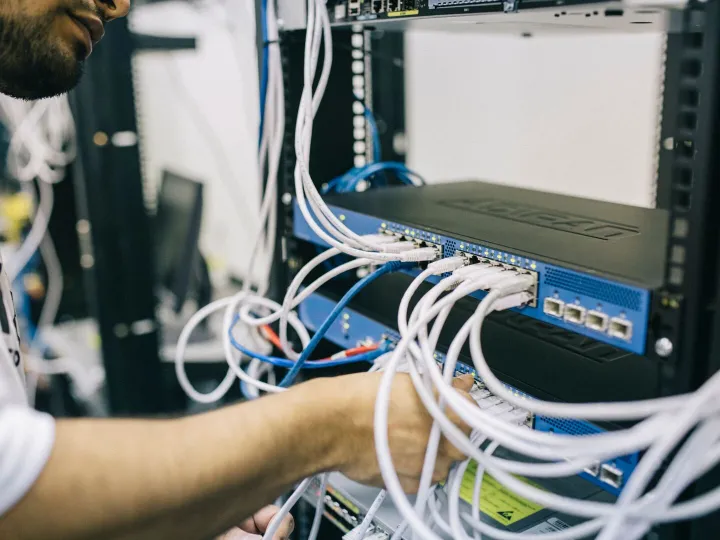 An engineer connecting network cables in a server rack