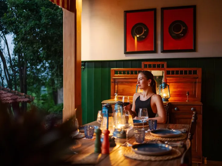 A guest at the dining table by lamplight at Peacock Hill Sigiriya