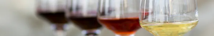 Four glasses of wine on a wooden platter