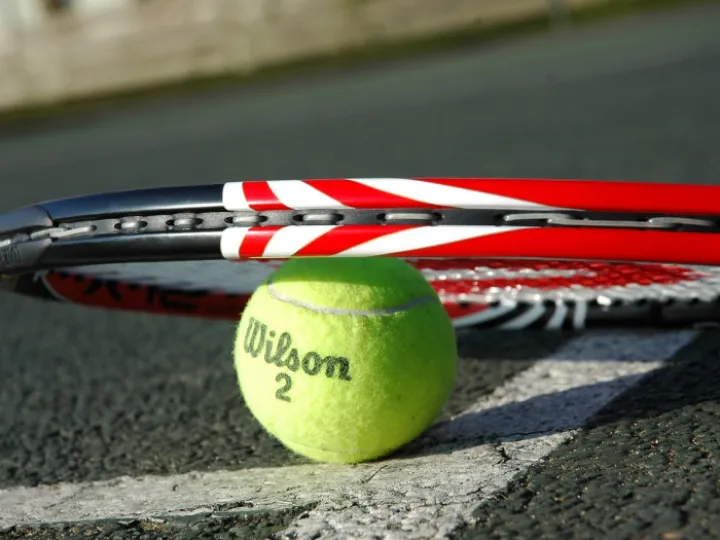 Tennis racket and ball on court
